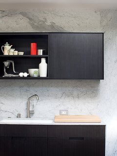 In paring back the home's aesthetic, Chris kept the color palette as simple as possible. Limiting the surfaces to either painted white or stained black allows colorful art, objects, furniture, and people to really pop.