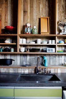 With its reclaimed-wood cladding, the kitchen is a rough-and-ready backdrop for the family’s tableware.