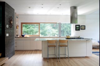 Gable-Roofed Rural Weekend Home in Connecticut - Photo 8 of 9 - In the kitchen, a Sirius range hood hovers over <br><br>a Wolf cooktop. The bleached ash cabinets were designed by JIG Design Build, the fabrication arm of Gray Organschi Architecture.