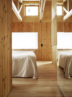 10 Warm Wood Floors - Photo 8 of 10 - The white linens appear almost ghostly against the natural grain of the wood and muted glow of the window's winter light.