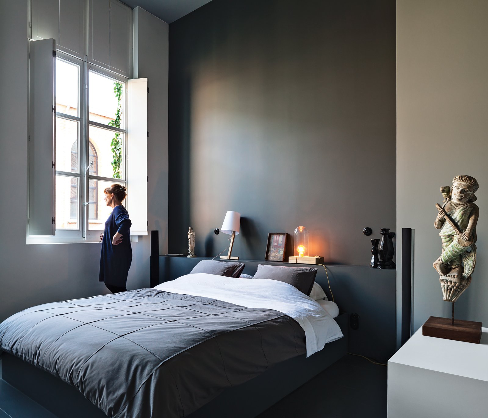 Wenes and Lens conceptualized a gradation of white to gray hues for the walls of the 1,500-square-foot gallery into the 4,000-square-foot home, culminating in a deep gray for the master bedroom. The room is reserved for meaningful pieces from the couple’s collection, such as a figure they found at a market in Beijing and lamps by artists Wenes represents.