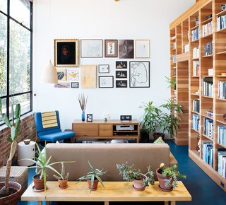 The picture wall is adorned with images collected from family, colleagues, and estate sales. "I kill plants, so cacti are our friends," Peter says of the succulents along the low table behind the Design Within Reach sofa, just over which an Established & Sons Font clock keeps time.