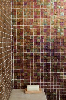 Coast Docs - Photo 12 of 13 - The bathrooms feature Oceanside Glasstile recycled glass tiles from Mission Tile West, in palettes inspired by the home’s coastal setting. The ground-floor bathroom is tiled in brown like the earth, the guest bathroom in seafoam green, and the master bathroom in blue like the sky.