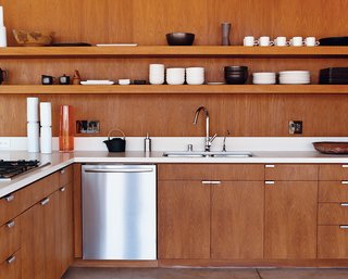 The kitchen cabinetry, custom designed by the architects, is smooth brown teak. The faucet is by Hansgrohe, and the dishwasher is by Bosch.