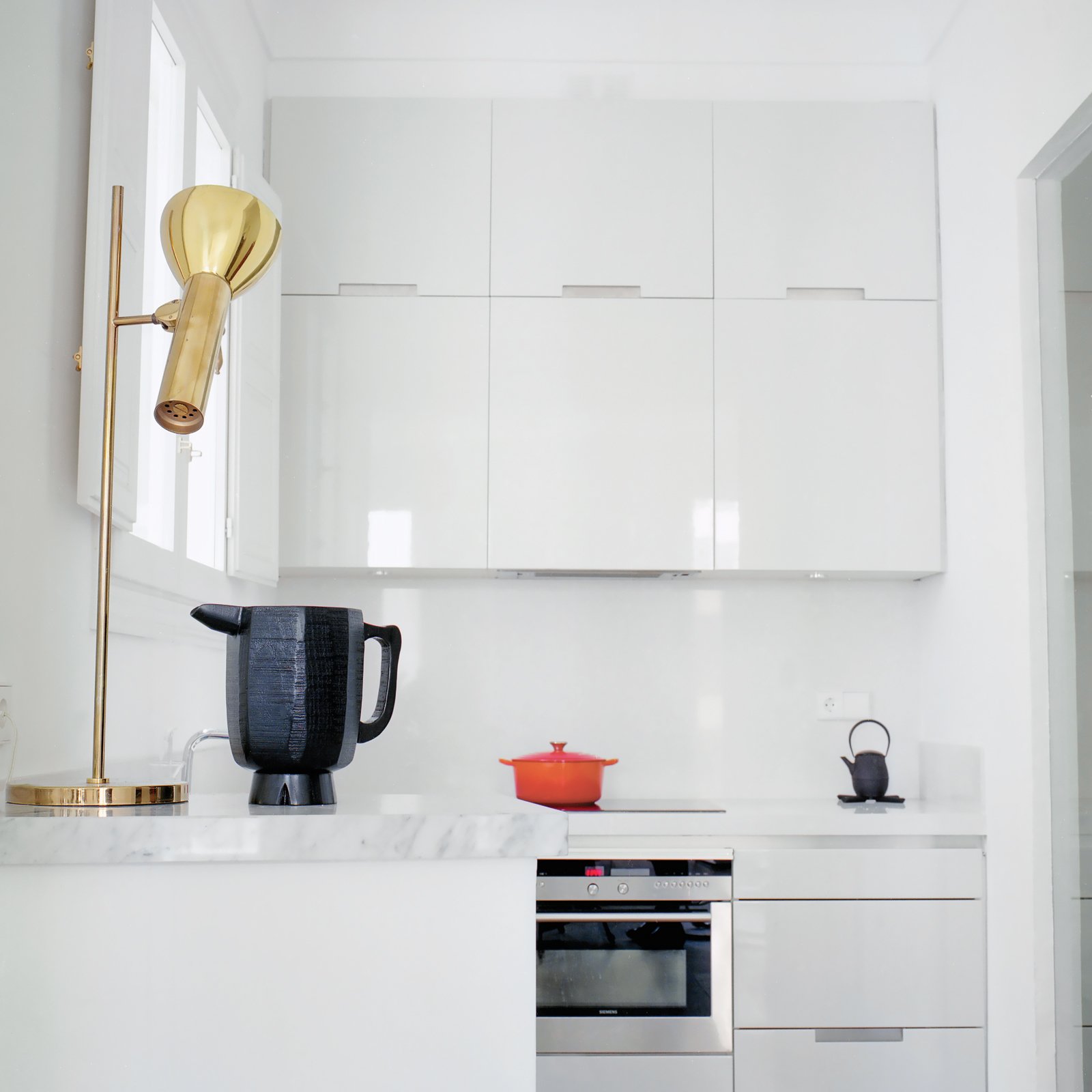 Hayon and Klunder’s kitchen is all white, down to the minimalist, lacquered Santos cabinets. When it comes to picking paint and fabric colors, Hayon advocates for grayed-out hues. “My recommendation is that even when you use bolder colors make sure they have a percentage of gray in them,” he says. “If you use yellow, it should be yellow-gray. If a green is used it should be a green-gray.”