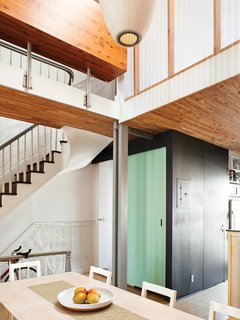 The dining area is bright and airy, thanks to the skylight-topped hole cut in the center of the structure. The ceiling is clad in cedar closet liner; the dining chairs and table base are from Ikea.