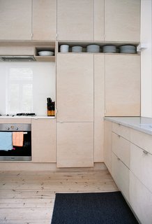 Budget-Friendly Renovation of a Neoclassical Home in Oslo - Photo 10 of 11 - A translucent glass backsplash in the kitchen lets light into the bedroom.