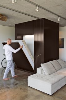 By lowering the custom Murphy bed and rolling a sliding plywood door, Novak-Zemplinski creates an insta-guestroom.