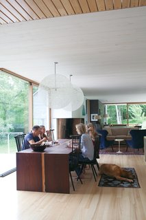 Gable-Roofed Rural Weekend Home in Connecticut - Photo 1 of 9 - The family relaxes in their home’s dining <br><br>room, sited atop the old foundation. Organschi designed and fabricated the table of wenge wood; the chairs were inherited from his uncle; and the pendant lights are Bertjan <br><br>Pot designs for Moooi.