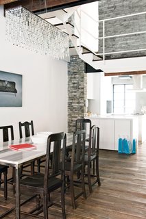 Modern Lilong House Renovation in Shanghai - Photo 5 of 11 - The dining room features vintage chairs. The table and kitchen cabinets are custom pieces by Carbone; the chandelier came from a local shop.