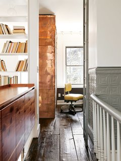The copper-covered volume extends from the first floor, where it contains coat and shoe storage.