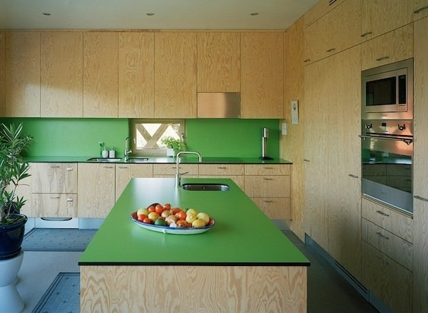 For the Garden House in Viksberg, Sweden, Tham & Videgård Arkitekter plotted the living quarters as a steep triangle with a bright-green kitchen in one corner. The green laminate countertops by Abet Laminati contrasts the raw plywood cabinets.