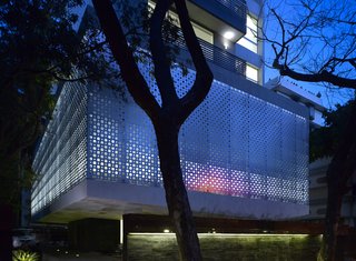 The perforated aluminum cladding surrounds the lower-level public area, which contains the pools and gym for the tenants. Khanna and Schultz played with the idea of using stainless steel, but found that aluminum had the appropriate strength for the building's needs. "With the lights glowing from inside, it turns the whole building into a big lantern at night," says Schultz.