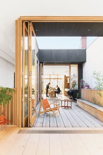 These Shop Owners Have a Killer Apartment Right Upstairs - Photo 4 of 10 - A third-floor courtyard stands in for a backyard and gives Elodie, the couple’s two-year-old daughter, a place to play outdoors. A Hunting chair by Børge Mogensen shares the space with a child’s chair by Tomii Takashi and a vintage Danish coffee table.