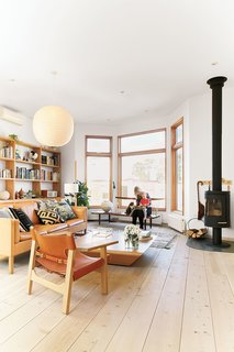 These Shop Owners Have a Killer Apartment Right Upstairs - Photo 8 of 10 - The living room is anchored by a sofa and lounge chair, both by Børge Mogensen, as well as a Conoid bench by George Nakashima. An Isamu Noguchi pendant lamp casts a warm glow onto the Brasilia coffee table, designed by Claesson Koivisto Rune for Swedese.