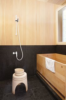These Shop Owners Have a Killer Apartment Right Upstairs - Photo 9 of 10 - A Japanese hinoki bowl and stool from Mjölk sit next to a custom hinoki bathtub by Bartok Design in the tub room.