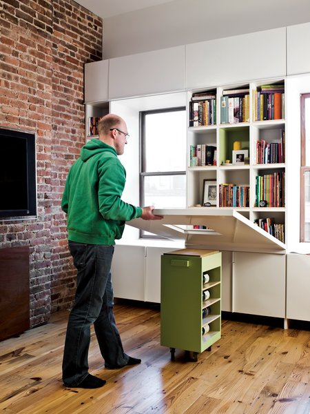 When it’s time to eat or do homework, the adults lower the tabletop, revealing a dozen book cubbies.