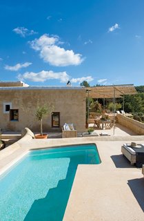This Designer Escapes to Ibiza for Some Peace and Quiet - Photo 2 of 9 - The architects discreetly sunk a pool into the roof terrace of the old corral. In order to shade part of the terrace, the architects designed a freestanding sun shelter. So as not to damage the outer walls of the old building, a galvanized-steel frame is secured to the terrace floor. A bamboo-reed covering projects a soft, filtered light onto the outdoor living area below.