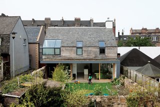 The framed aluminum of the corner window by Natralight breaks up the roof of recycled slate tiles, which is entirely of a piece with the roofs around it. The Scottish oak cladding comes from Abbey Timber and the black aluminum cladding from MSP Scotland.