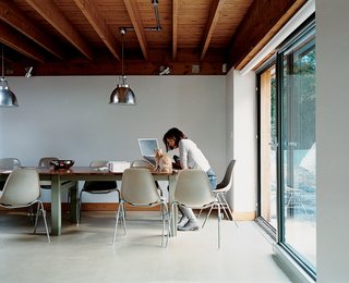 The dining area opens to the expansive grounds, and is furnished with Eames fiberglass shell chairs.
