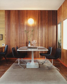 In the dining area, Metropolitan side chairs by Jeffrey Bernett for B&B Italia surround a Surf Table designed by Carlo Colombo for Zanotta.