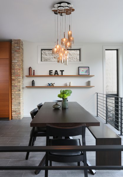 Fisher advises that comfort, functionality, and durability are key to selecting furniture. “I don’t care how big your budget is, there is no point wasting money on something that looks good, but doesn’t function for you, or is easily damaged or stained,” Fisher says. In the dining room, she opted for a Cross Extension table and Profile chairs from Design Within Reach and a custom bench by JJ Woodwork. The Spillray pendants are by Axolight. Photo 6 of Lakeview modern home