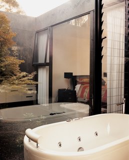 The guest bathroom includes glass walls that look out onto one of the house’s "voids," in which pear trees grow.