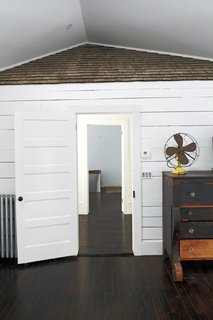 A section of the farmhouse’s original shingled roof peeks out from under the new, raised ceiling in the master bedroom.