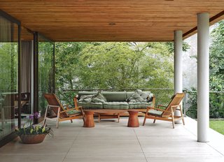 The travertine terrace just beyond the living room has a pair of chairs, coffee table, and sofa by local furniture maker Saccaro.