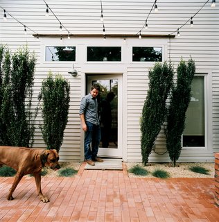 Salvage Love - Photo 1 of 10 - From the side door of his restored two-bedroom bungalow, Dollahite watches his <br><br>dog West inspect the newly installed low-maintenance landscaping and brick patio.