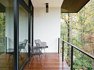 Wire chairs by Rejuvenation and pendants by Hinkley Lighting grace the balcony outside.