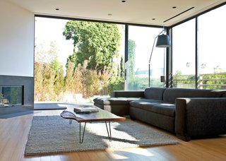 You Won't Be Calling This House a "Man Cave" - Photo 3 of 9 - The sofa is from Cantoni, the rug is from Restoration Hardware, and the Tolomeo floor lamp is by Michele De Lucchi for Artemide. The large windows in the background and throughout the house are from Western Window Systems.