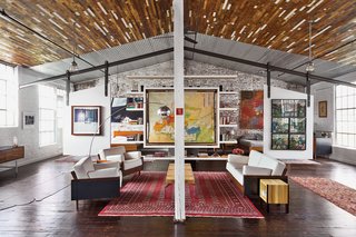 Beneath a recycled-wood ceiling and centered by a Bokhara rug, the living area contains furniture of their own design.