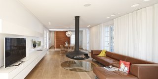 One of the biggest parts of the remodel was removing walls on the ground floor to make space for more of an open plan. The hanging steel Gyrofocus Fireplace by Focus gives the living room a unique character. It's flanked by a Delphi sofa from Erik Jørgensen.