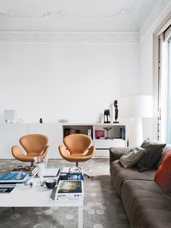In the living room of the Barcelona apartment designer Elina Vila D’Acosta-Calheiros shares with her husband, Ginés Gorriz, Arne Jacobsen Swan chairs join a sofa by Piero Lissoni for Living Divani. The cabinet is from Cappellini, as is the Marcel Wanders Big Shadow lamp.