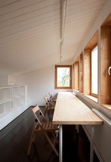 A Compact Home in Moscow Built on the Lowest Possible Budget - Photo 9 of 9 - Near custom pine shelving on the third floor, folding chairs and a table from IKEA provide a tranquil space for studying.