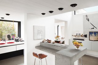 A Concrete Home in Rural Belgium - Photo 4 of 9 - De Poorter refurbished the original red sinks and black-and-white cabinets in the home’s 1970s kitchen. Instead of ripping out what some may consider dated trimmings, Vandemoortele says, "I wanted to keep some parts of the house’s history. I think that renovation often goes too far."