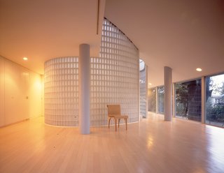 "Hanegi Forest–architecture among trees, designed by Shigeru Ban in 2007. The challenge was to avoid pulling down a single tree in the forest and to build a house around them. Shigeru Ban’s home is in this building, which stands immobile in a tranquil Tokyo district. A round table, a Terragni chair, a Greek face and masses of light. Nothing else, a Zen monk’s room." 