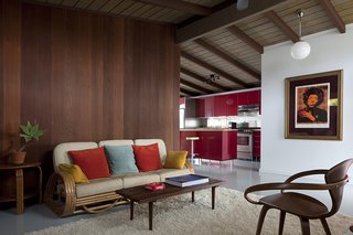 A Cherner Chair Retrospective - Photo 4 of 23 - The existing partitions were tongue-and-groove redwood. To update the interior, each panel was painstakingly removed, refinished in a darker hue, and replaced. The centerpiece, a four-strand rattan couch, is complimented by other wooden pieces, like this original Cherner chair, also a Craigslist purchase.
