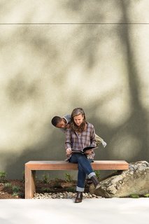 Birdsall and Atticus are seated on an ipe bench designed by Anna Boeschenstein; the stucco exterior cladding was matched to Cast Iron 6202 paint by Sherwin-Williams.