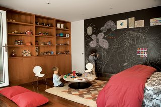 Writing on the walls is encouraged by the magnetic slate chalkboard from Claridge Products. The Phoenix table by Patricia Urquiola for Moroso does double duty as a play table or a coffee table, depending upon who’s in residence. The Tulips felt rug is from Peace Industry, and was made in a fair-trade workshop in Iran. The casework is constructed of anigre wood.