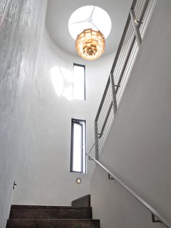 Crowning the interior hallway is a Louis Poulsen PH Artichoke pendant, designed in 1958. The narrow apertures were designed to funnel the ocean breeze, contributing to the home’s passive cooling program. The walls are covered in American Clay, which helps to control humidity.<br><br>To learn more about the Cranston Residence project and its players, please visit www.3palmsproject.com