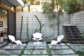 The First LEED Gold-Certified Family Home in San Diego - Photo 11 of 13 - Outside, a set of Bertoia chairs offer an appealing perch around a vintage glass-and-metal table.