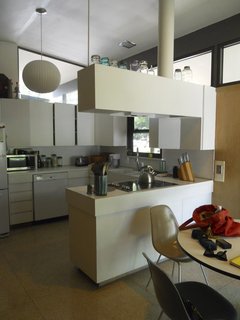 BEFORE: Prior to renovation, the kitchen's storage came in the form of all white cabinetry arranged in an enclosing, C-shaped space.