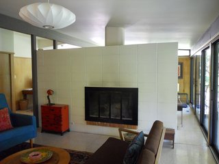 BEFORE: Looking disjointed, the living room in the pre-renovation Houser home is an alienated space, occluded from the natural light entering the spaces just beyond.
