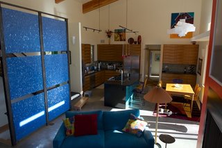 Mountaintop Modern - Photo 3 of 8 - An accent wall, composed of cobalt-blue fractal panels from 3form, adds a bold dash of color to the great room. Barry Doyle built the kitchen cabinets with bookmatched koa veneer panels, giving them a distincitve, patterned look. Photo by Barry B. Doyle.