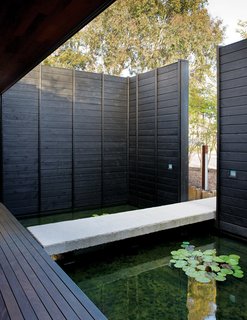 5 Sustainable Ways To Beat the Heat Without Air Conditioning - Photo 8 of 11 - Before entering the home, visitors pass through the cooled microclimate created by a front yard pond with a concrete footbridge.