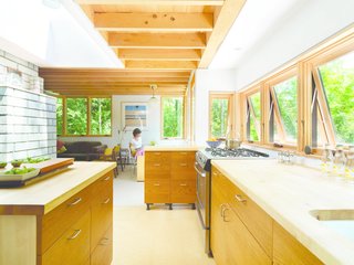 Daylight adds to the warm ambiance of the wooden millwork of the Nature Preserve House kitchen.