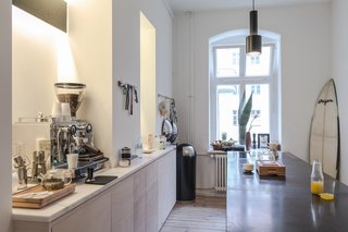 Kitchen of the Freunde von Freunden X Vitra ApartmentRide the wave: The sleek, open kitchen, centered around the custom black marble island with none-too-subtle Southern California callouts like the surfboard in the corner, is Frede’s favorite room. The kitchen fixtures and countertops are by Miele and Dornbract. Photo by Steve Herud