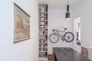 Kitchen of the Freunde von Freunden X Vitra ApartmentArchitect Etienne Descloux adjusted the original bathroom design to provide more space for storage in the kitchen. Bike by Mikili, flowers by Marsano.Photo by Steve Herud